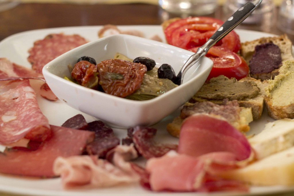 Antipasto toscano/Tuscan mixed starter of cold cuts, preserved vegetables, and toast with different spreads
