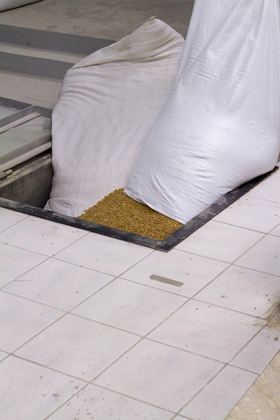Wheat being loaded into a hatch which supplies the mill