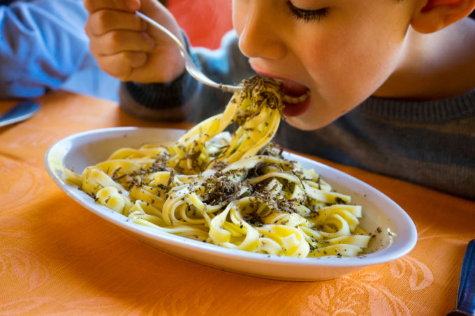 My son tucking into a plate of pasta with black truffles