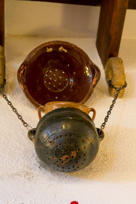 A traditional earthenware couscoussiere (perforated pot) which rests over a pan of boiling aromatised water to steam the couscous within. The gap between the couscoussiere and the pot is sealed with dough.